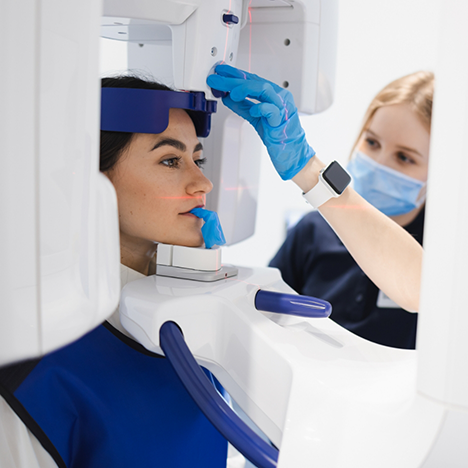 Female patient having cone beam scan taken by dental team member