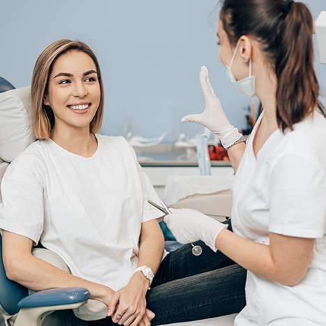 Female dental patient smiling at female dentist