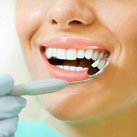 Using dental mirror to examine patient's teeth