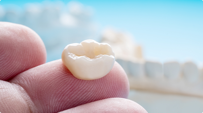 Close-up of dental crown in Lancaster on finger