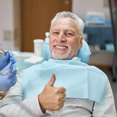 Male dental patient giving thumbs up