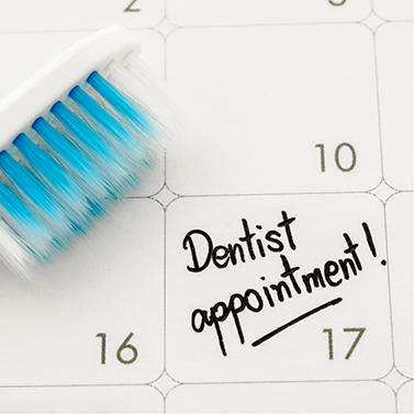 Calendar that says Dental Appointment with a toothbrush lying on it