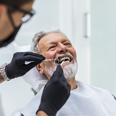 Man with beard having teeth examined by dentist