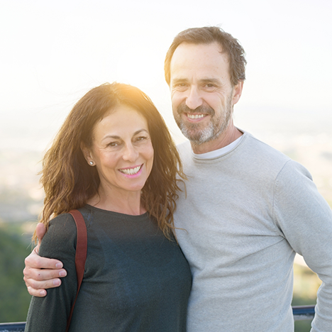 Smiling man hugging smiling woman from the side