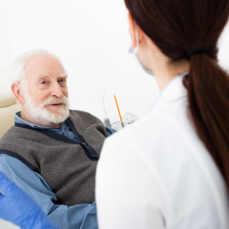 Senior man looking up at female dentist