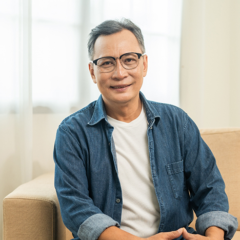 Man with glasses sitting on couch and smiling