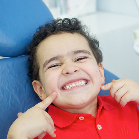 Close-up of little boy pointing to his smile