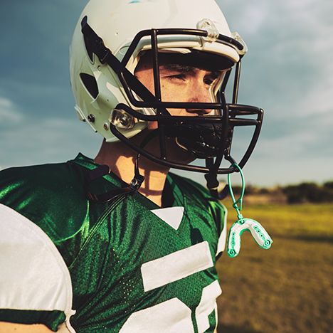 Child in football helmet with mouthguard