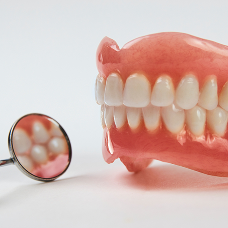 Close-up of denture and dental mirror