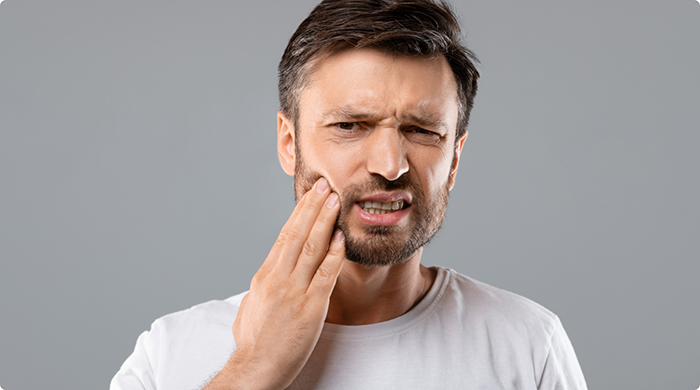 Close-up of man rubbing jaw in pain
