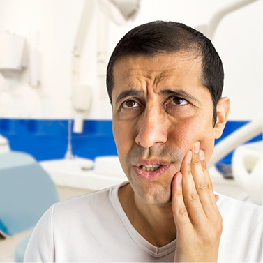 Man rubbing his jaw looking concerned