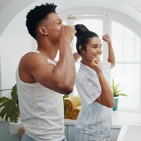 Man and woman brushing their teeth