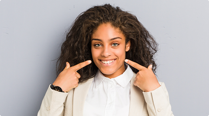 Woman pointing to her smile