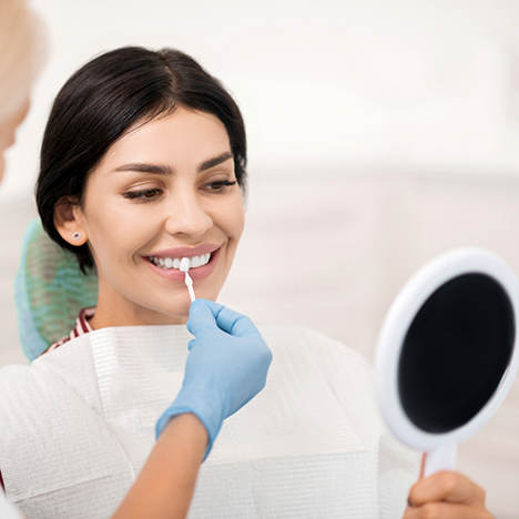 Woman having teeth shade matched for veneers