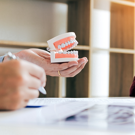 Filling out form and holding model of dentures