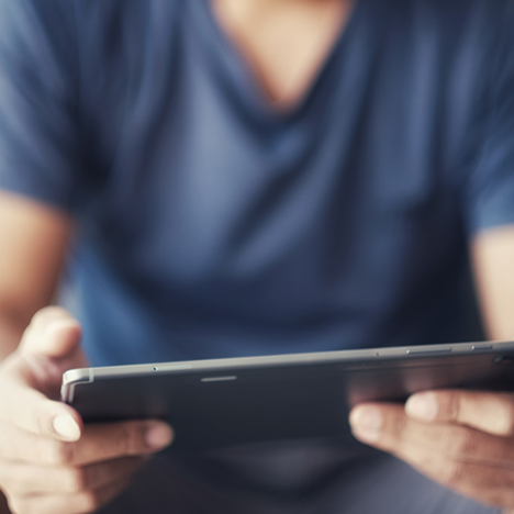 Man in blue shirt holding a tablet