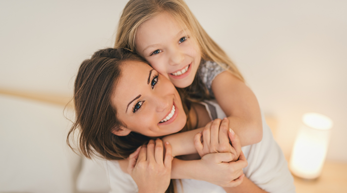 Woman giving little girl a piggyback ride