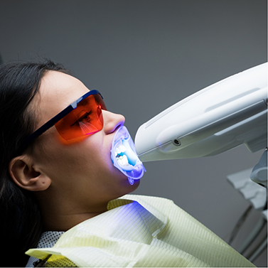 Woman having in-office teeth whitening performed