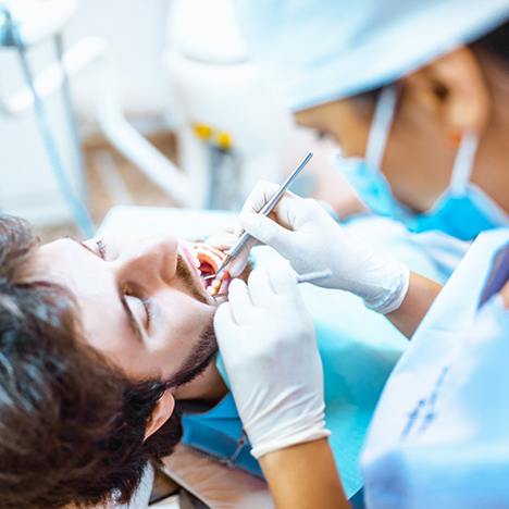 Male dental patient having tooth extracted