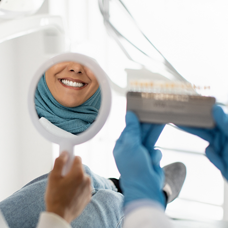 POV shot of patient checking smile in handheld mirror
