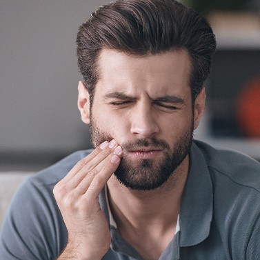 A bearded man experiencing a toothache