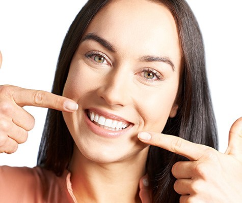 Smiling woman pointing to her teeth