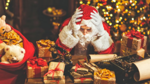 Santa stressing over a table full of letters and presents