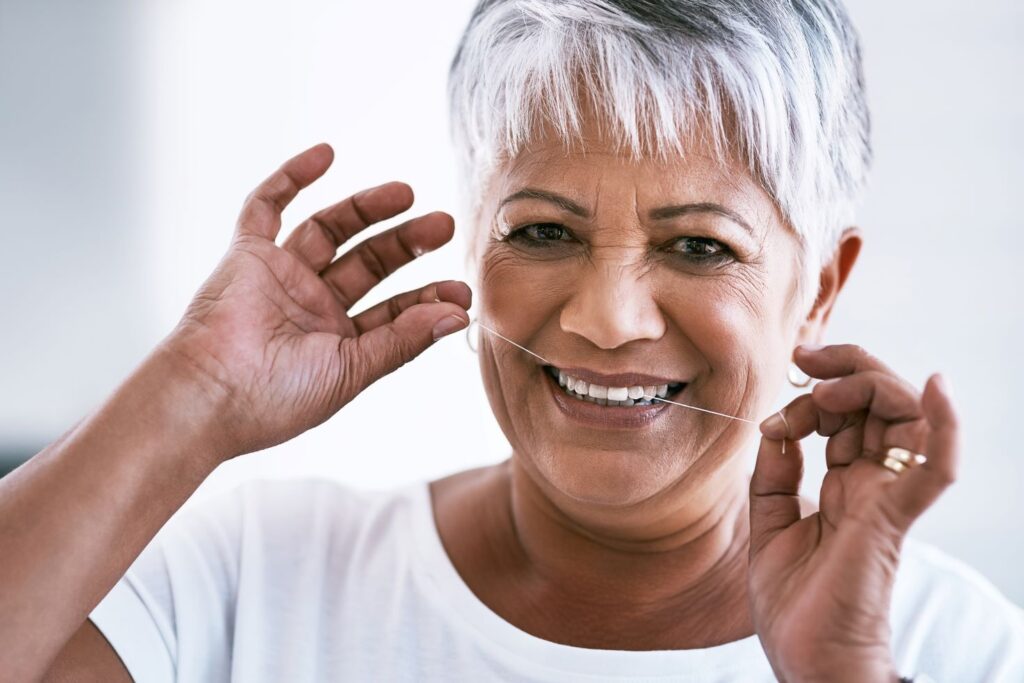 A woman flossing her teeth